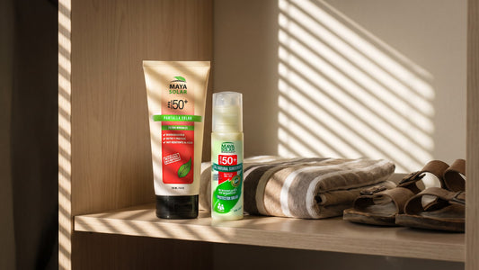 Bloqueador Solar en Crema FPS 50+ de Maya Solar en sus presentaciones de 204 ml y 75 ml, de pie sobre la repisa de madera de un clóset, junto a una toalla de playa doblada y unas sandalias guardadas para el verano