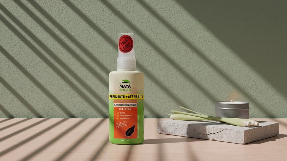 Repelente Natural After Bite de Maya Solar de 60 ml sobre una losa de piedra caliza, junto a una vela apagada y unos tallos de zacate limón, con la luz de una persiana rayando la pared verde