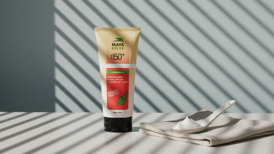Bloqueador solar en crema FPS 50+ de Maya Solar de 204 ml de pie sobre una mesa clara, junto a una cuchara de cerámica con una porción de crema sobre un lienzo de lino, bajo la luz rayada de una persiana